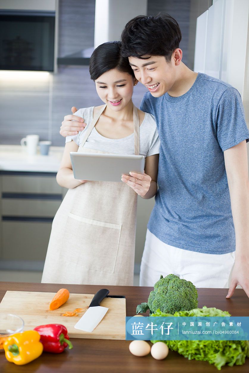 年轻夫妇在厨房使用平板电脑