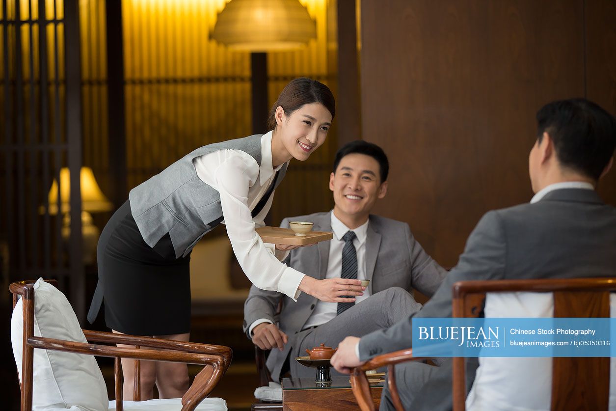 Cheerful Chinese businessmen talking in tea room