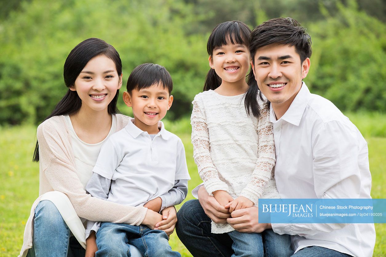 Portrait of happy young Chinese family with two children