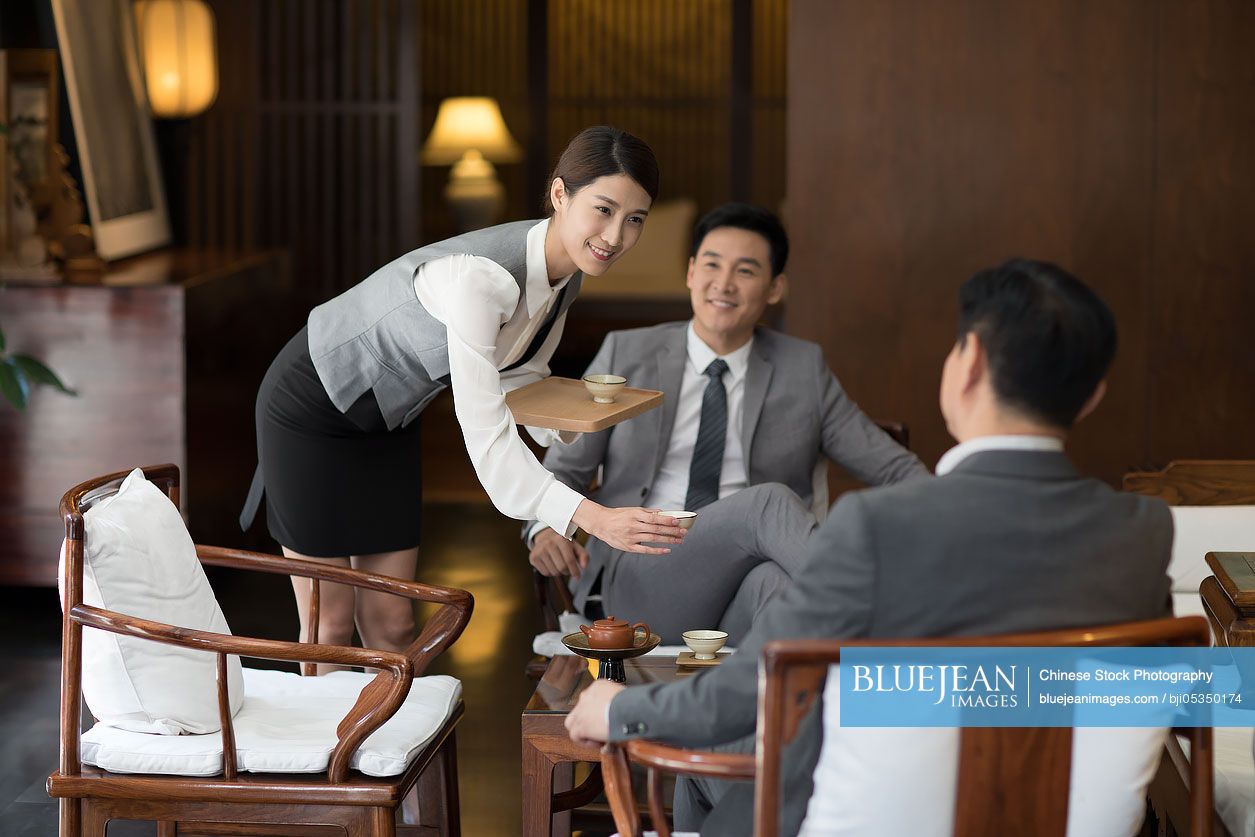 Cheerful Chinese businessmen talking in tea room