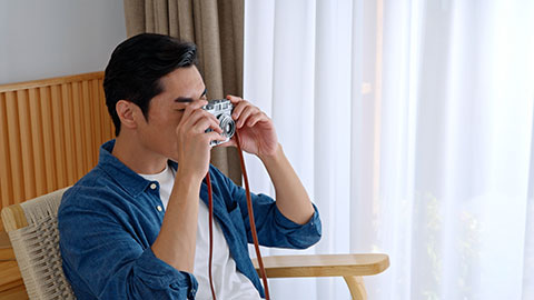 Chinese male photographer checking camera at home,4K