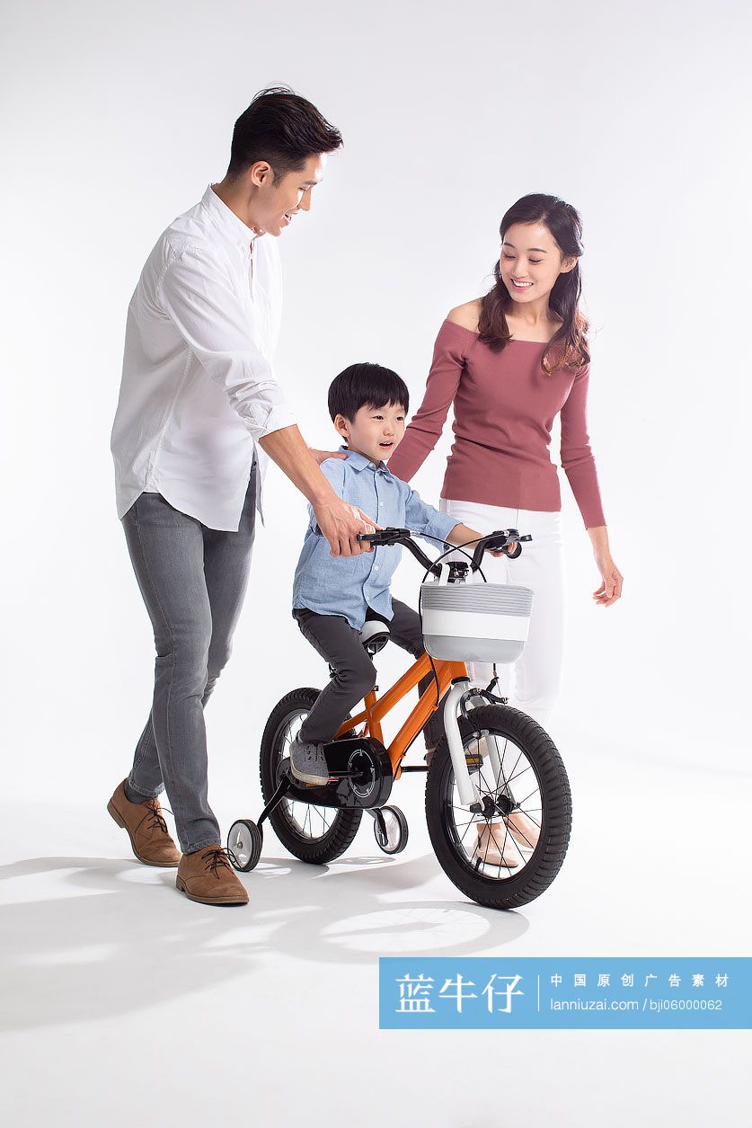 年轻父母教孩子骑自信车