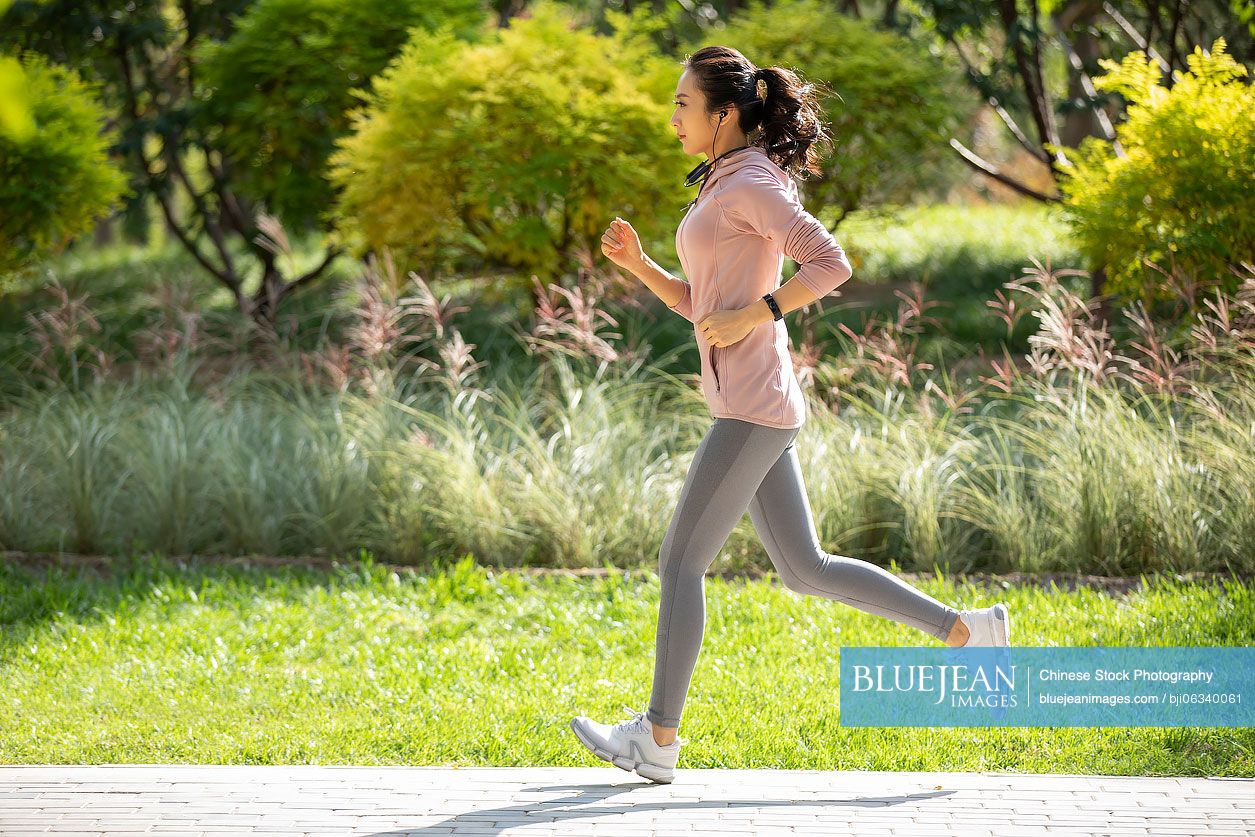 Young Chinese woman jogging in park