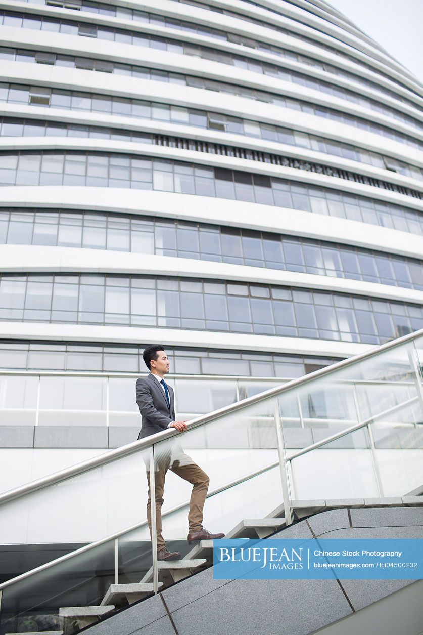 Chinese businessman standing in front of office building