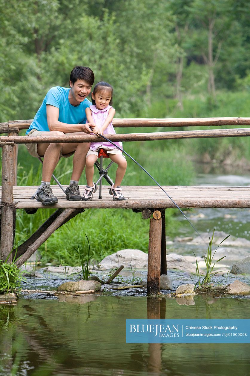 Portrait of Chinese father and daughter fishing