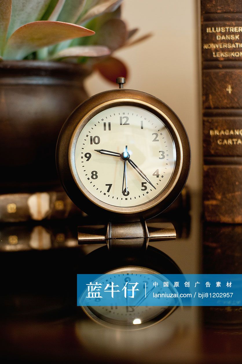 Close-up of a clock with reflection on table at home