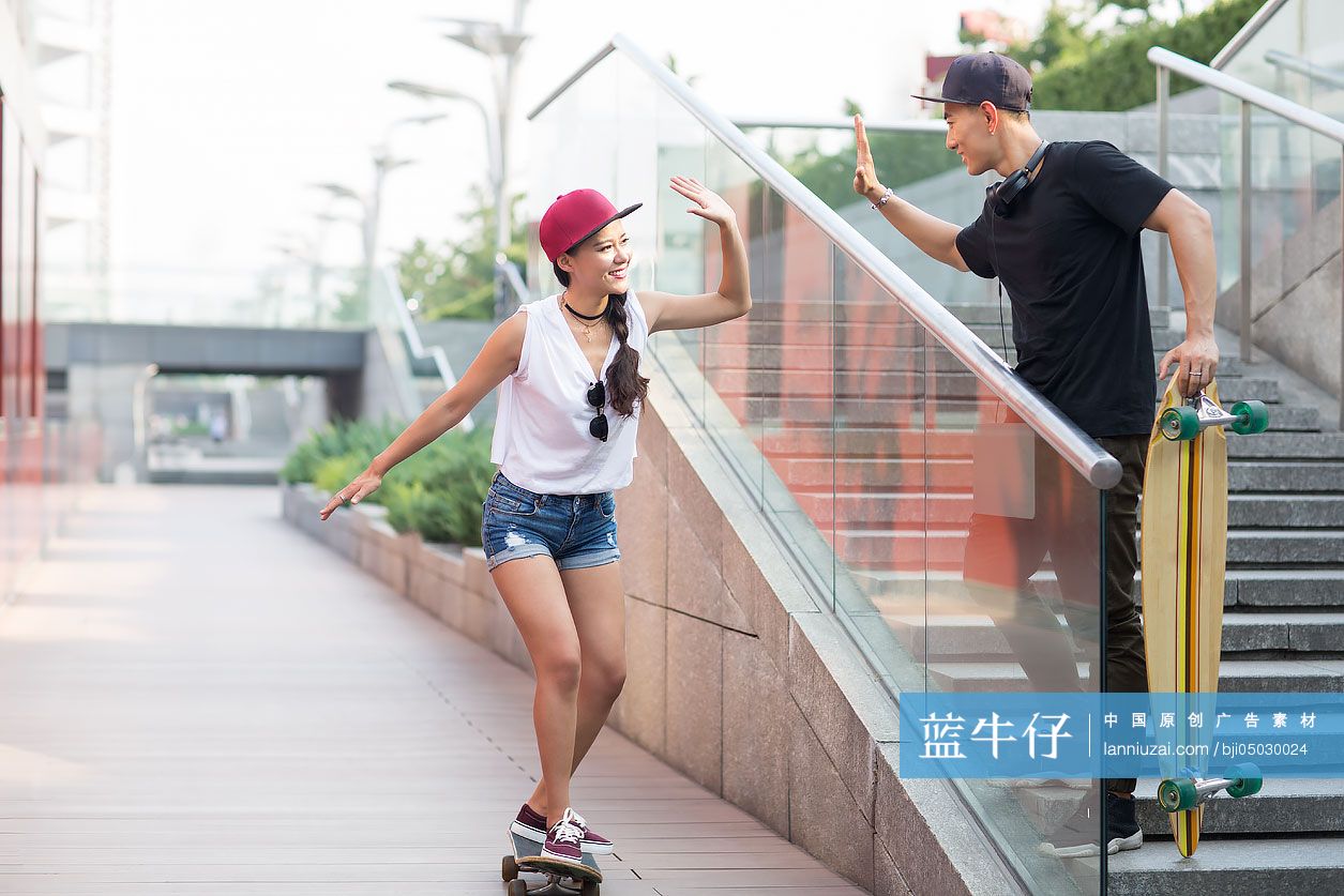 快乐的年轻情侣在滑滑板