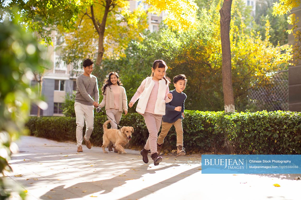 Happy young Chinese family with pet dog