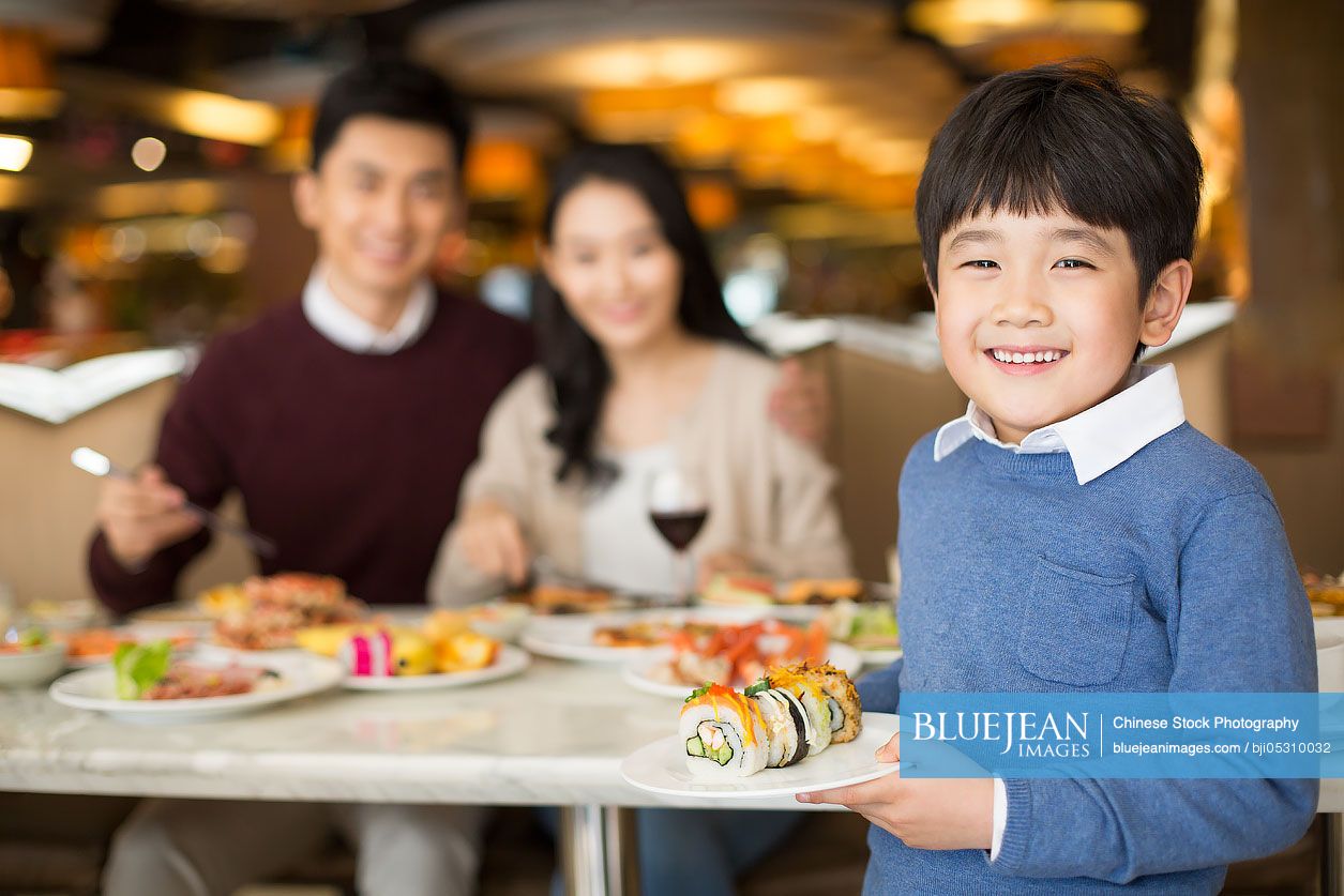 Cheerful young Chinese family having buffet dinner