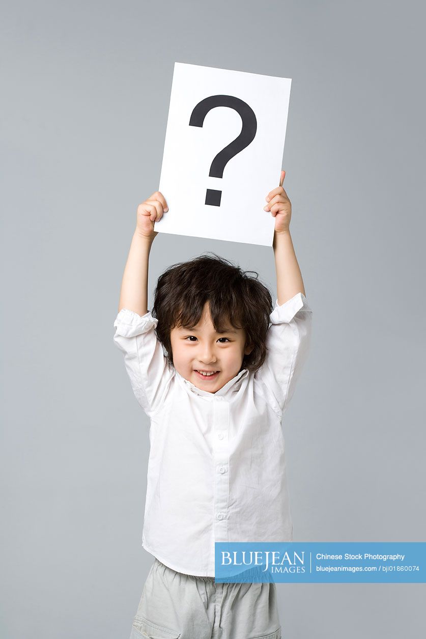 Little chinese boy holding a sign with a question mark high res stock
