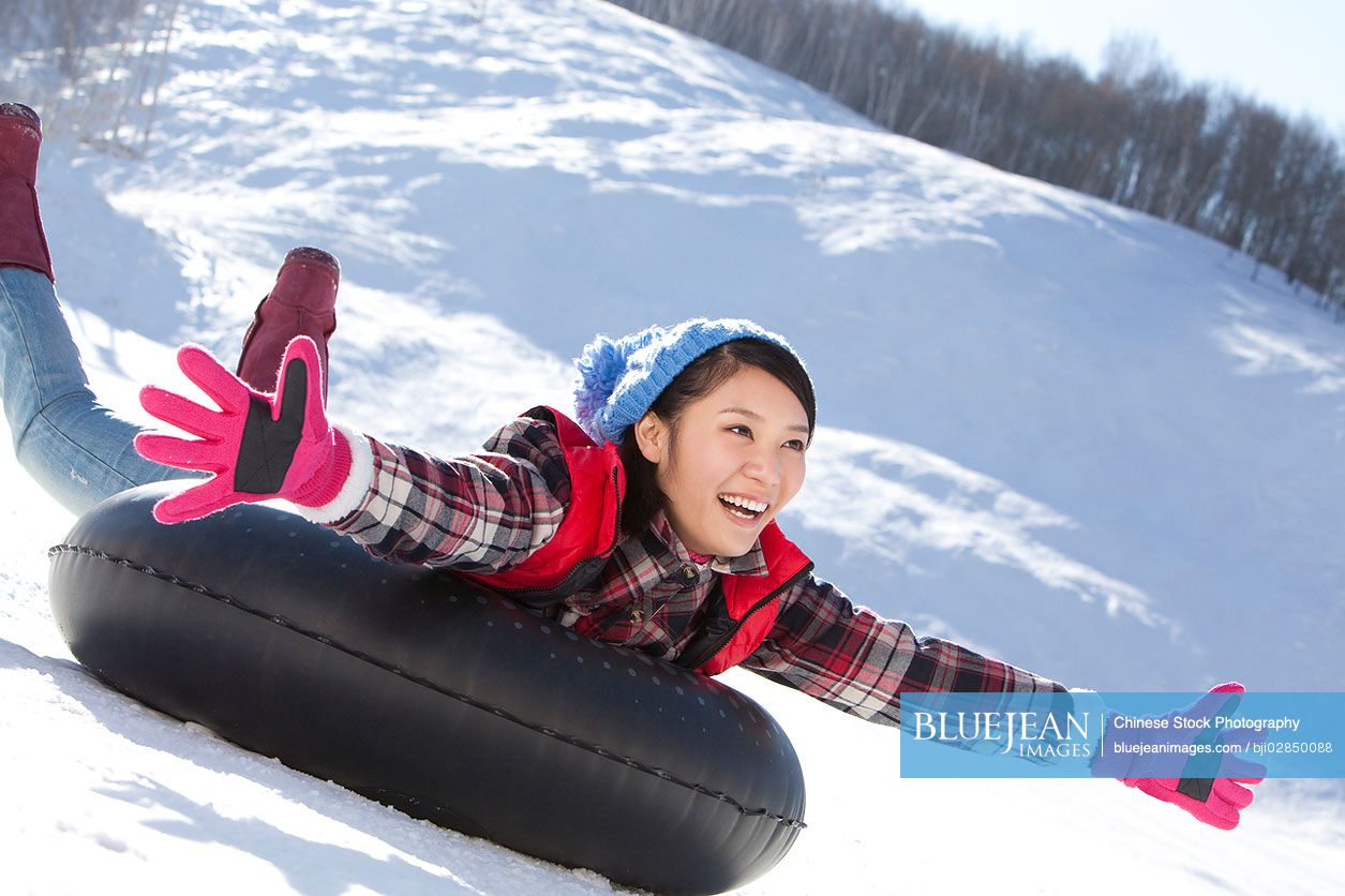 Happy young Chinese woman having fun in ski resort