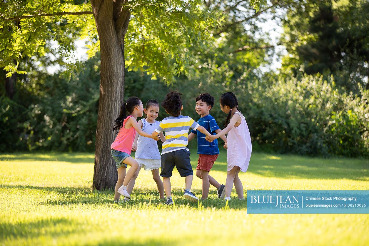 Happy Chinese children playing on meadow