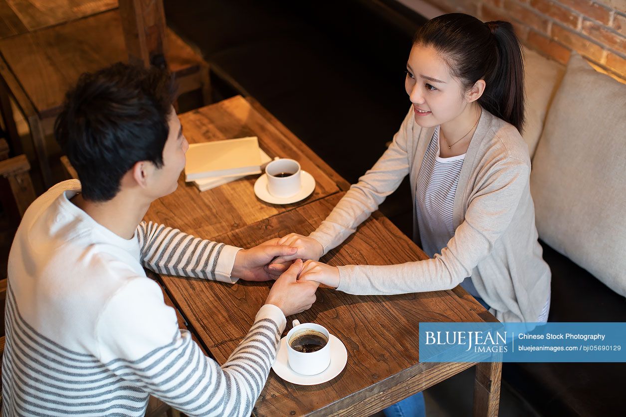 Young Chinese couple dating in coffee shop