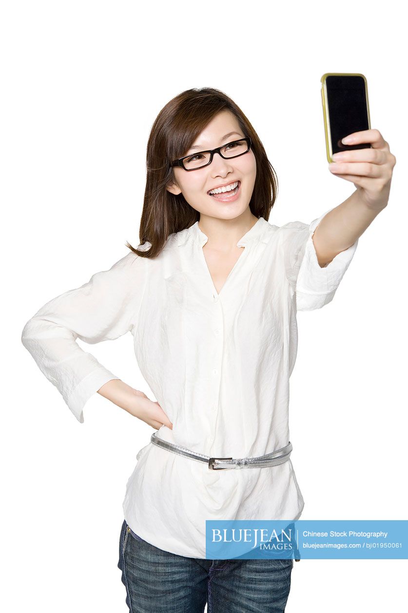 Portrait of young Chinese woman taking a photograph of herself