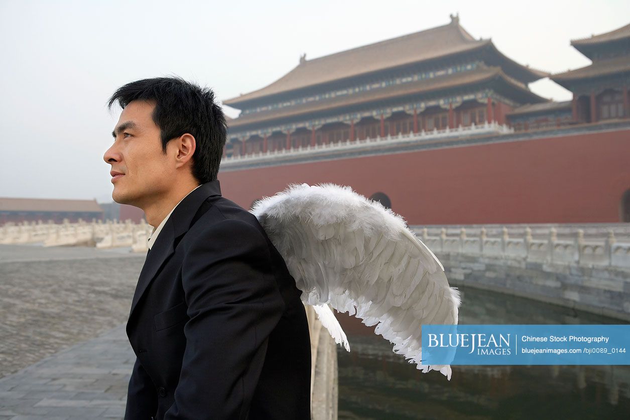 Chinese Man Wearing White Wings, Looking Pensive