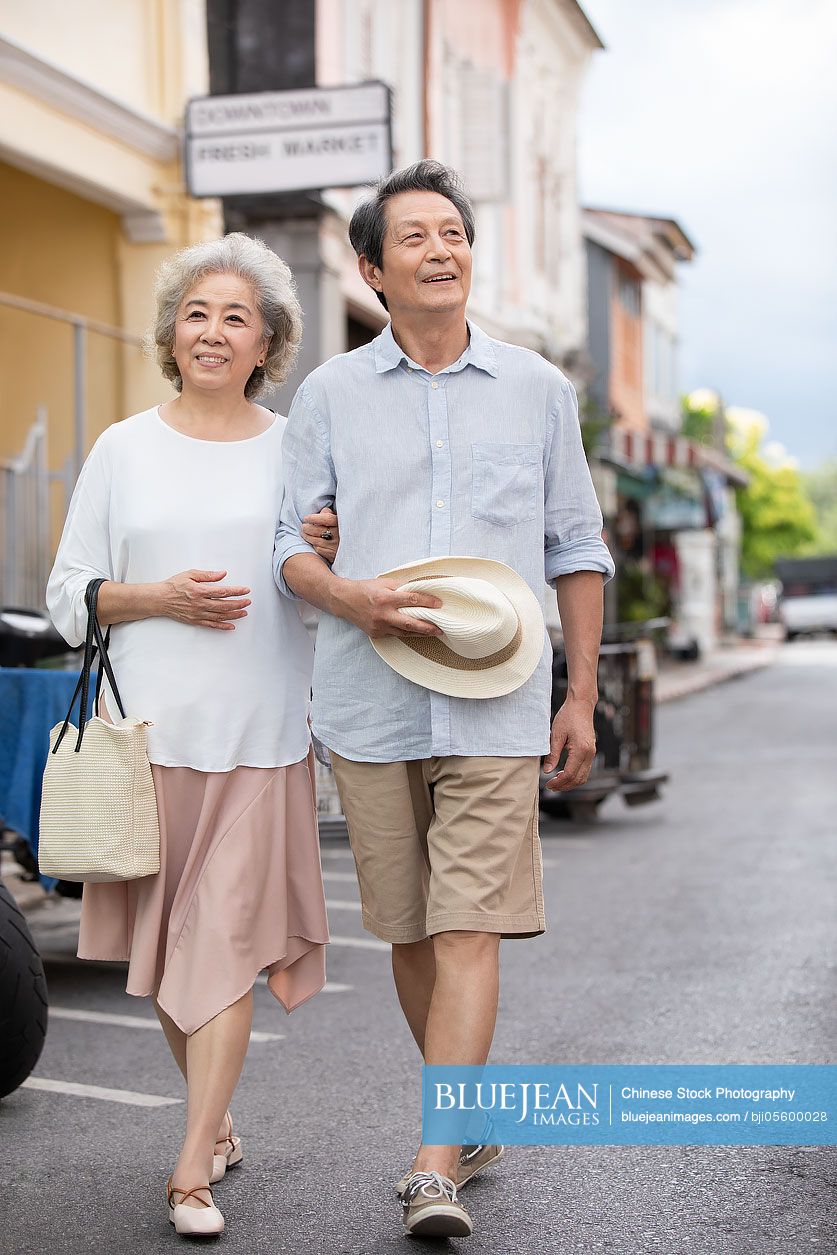 Happy senior Chinese couple walking on street-High-res stock photo for ...