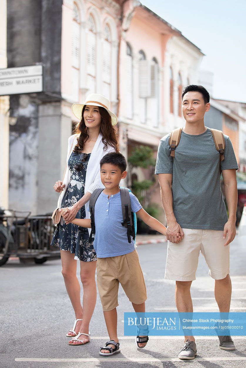 Happy young Chinese family enjoying vacation