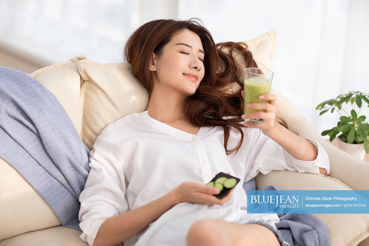 Young woman drinking juice at home