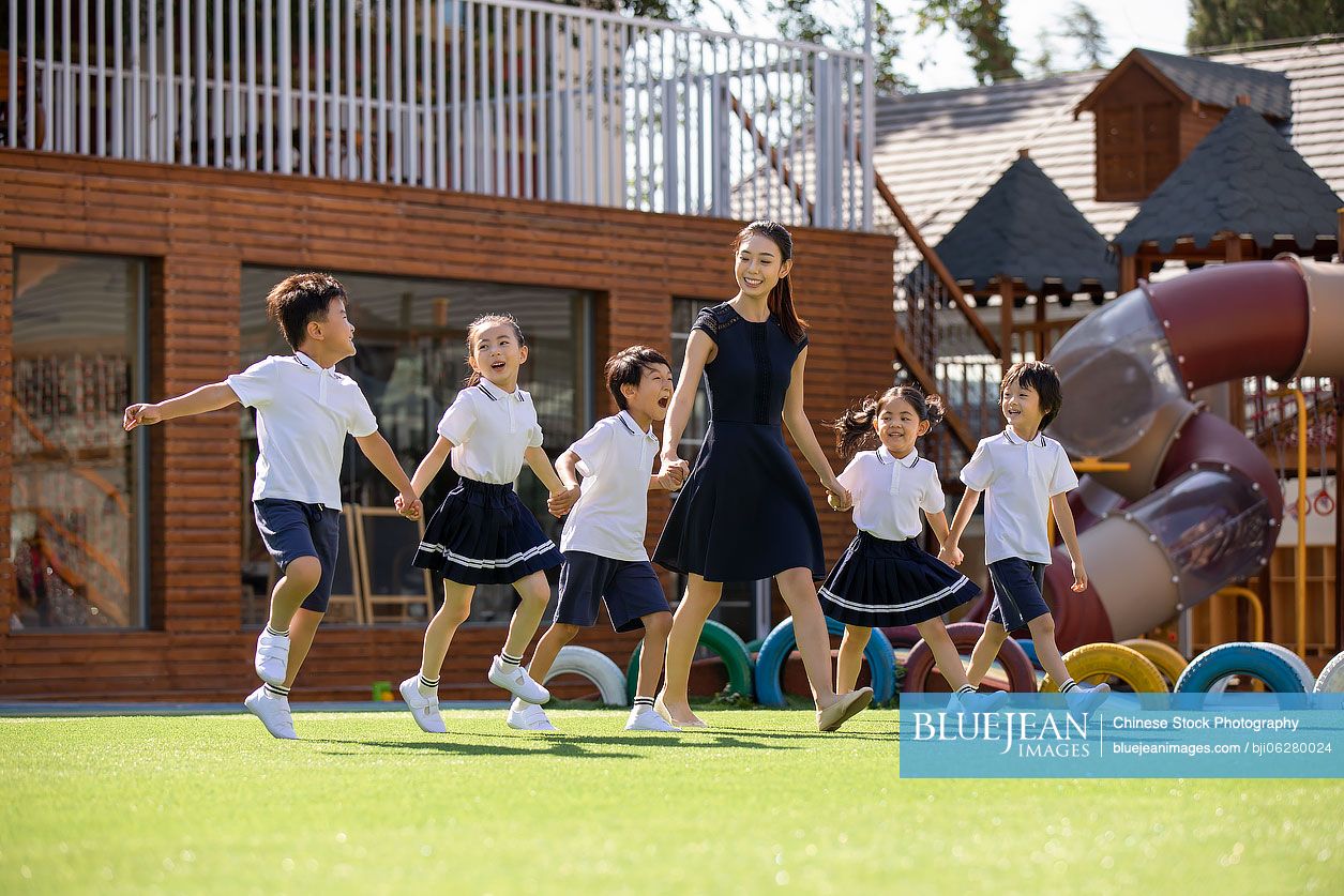 Chinese teacher and students in kindergarten playground
