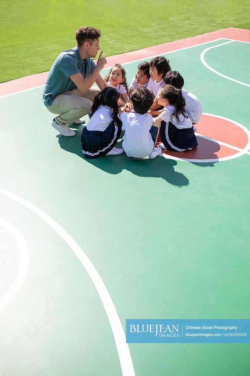 Foreign teacher and children playing in playground