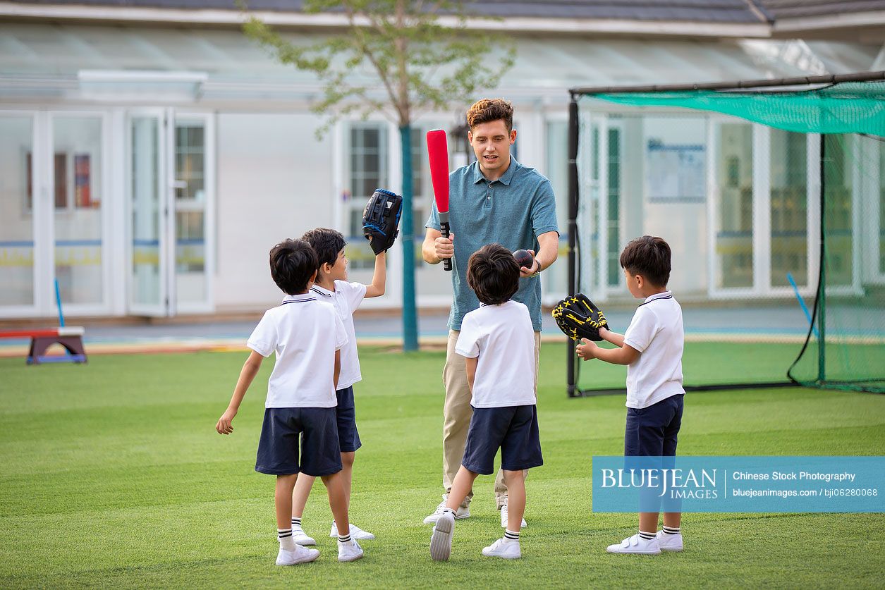 Foreign teacher teaching children basketball