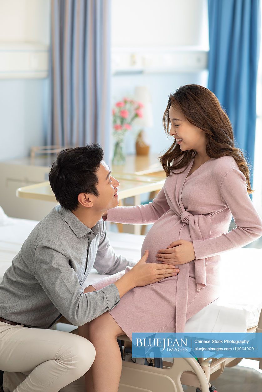 chinese-husband-touching-his-pregnant-wife-s-belly-in-hospital-ward