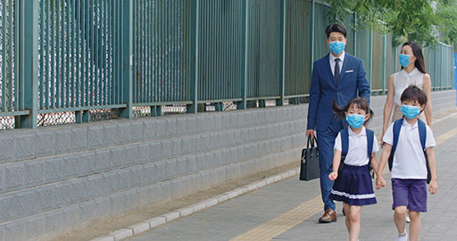 Young Chinese family wearing surgical masks and walking oudoors,4K