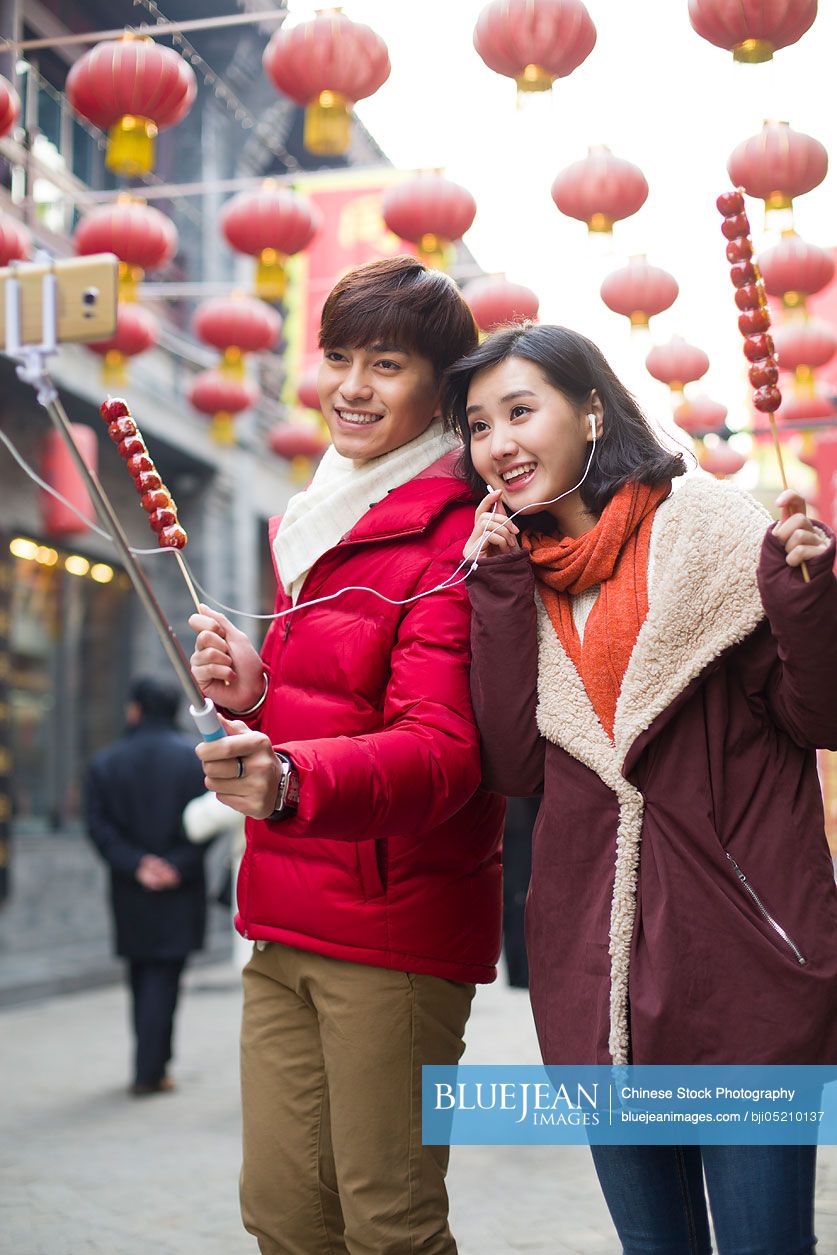 Young Chinese couple taking self portrait with a smart phone