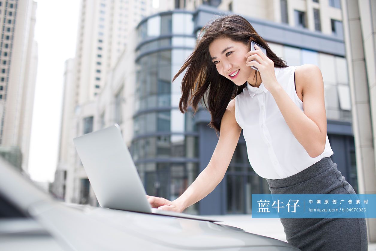 自信的商务女士在车旁打电话