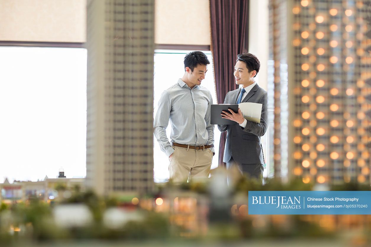 Chinese realtor showing architectural model to young man-High-res stock ...