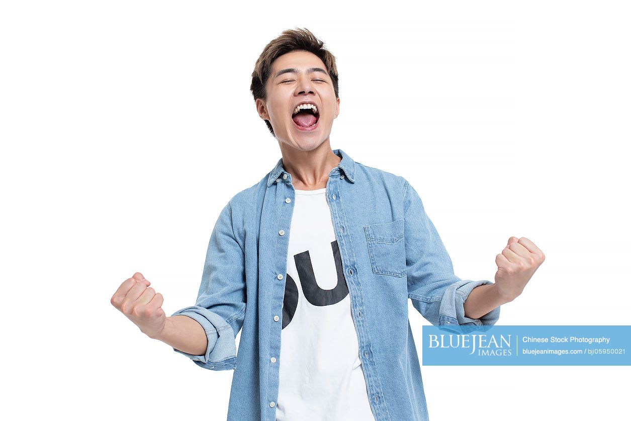 Happy young Chinese man punching the air
