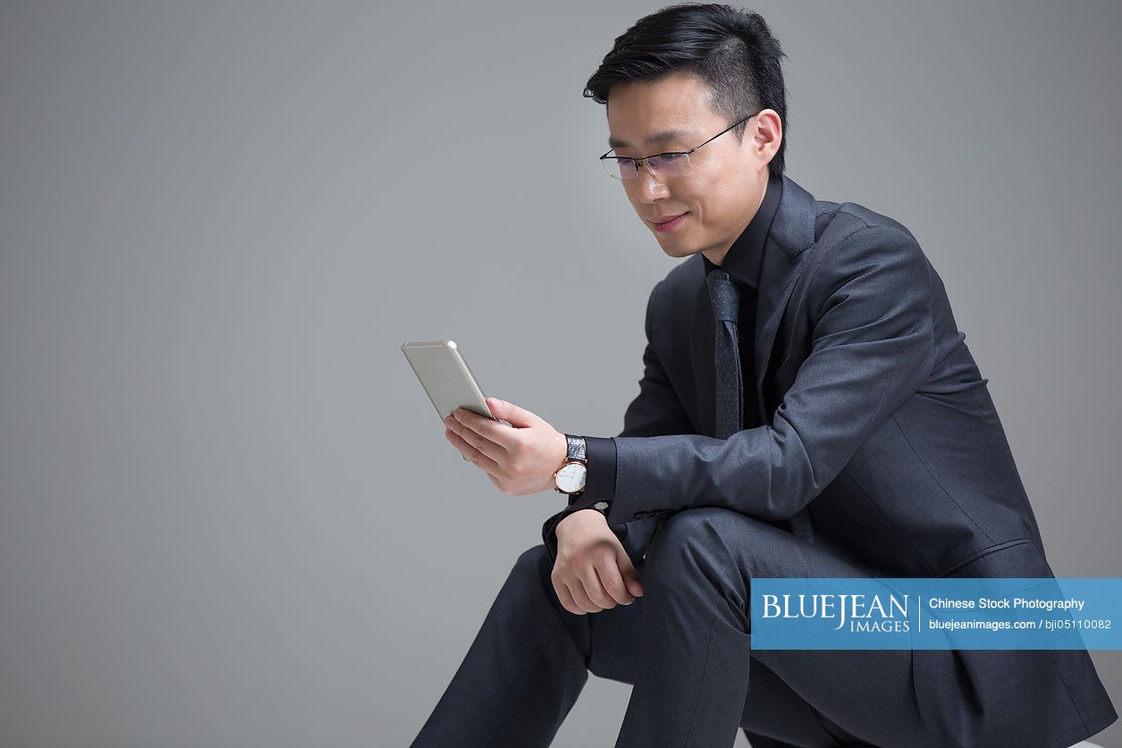 Mid adult Chinese businessman using smart phone