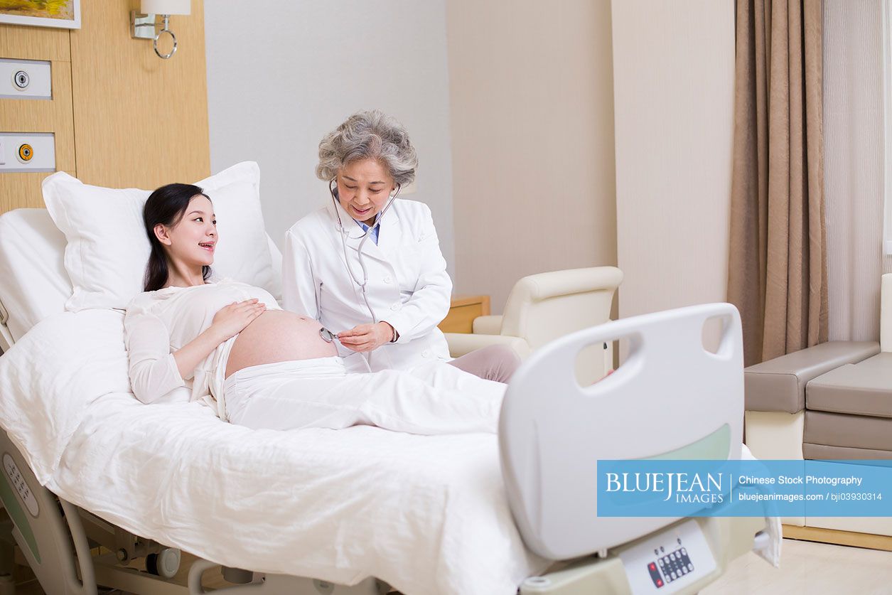 Chinese doctor examining pregnant woman