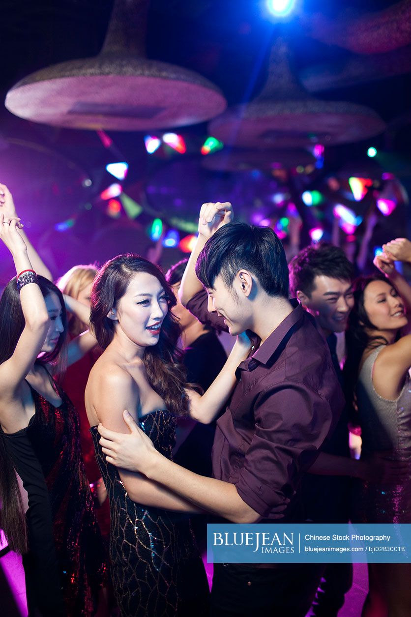 Stylish young Chinese dancing in nightclub