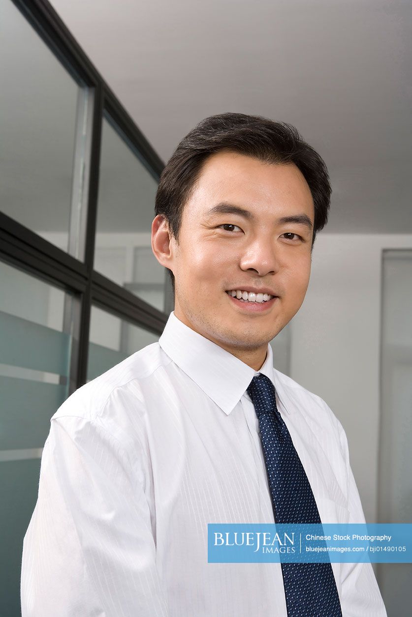 Portrait of young Chinese businessman in office