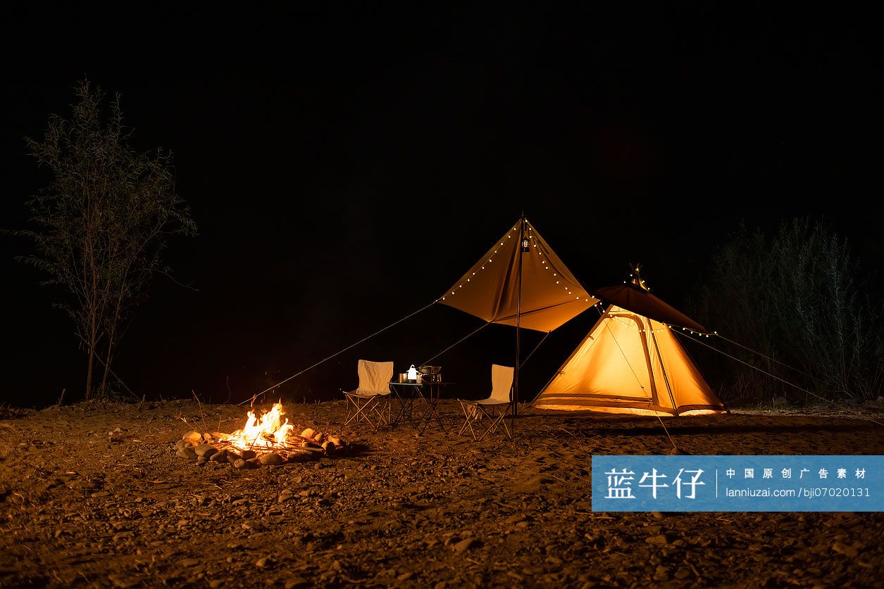 夜幕下的露营帐篷和篝火