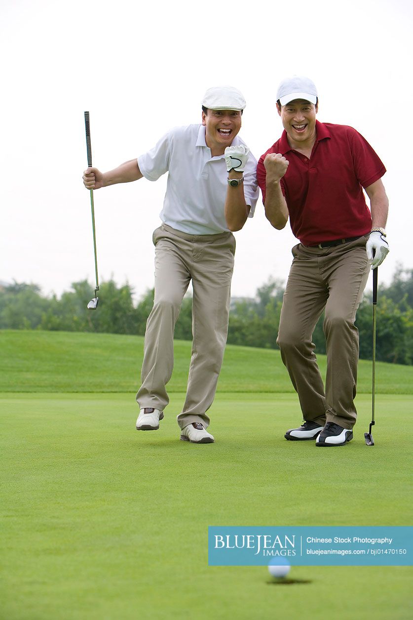 Two Chinese golfers celebrating a nice putt