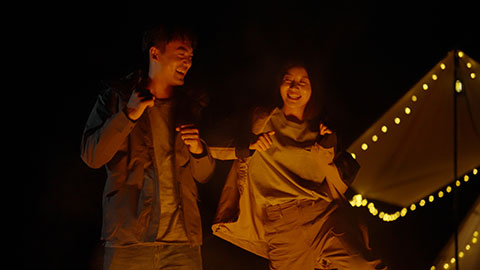 Happy young Chinese couple camping outdoors