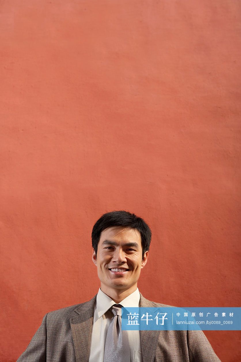 商务男士站在宫墙下