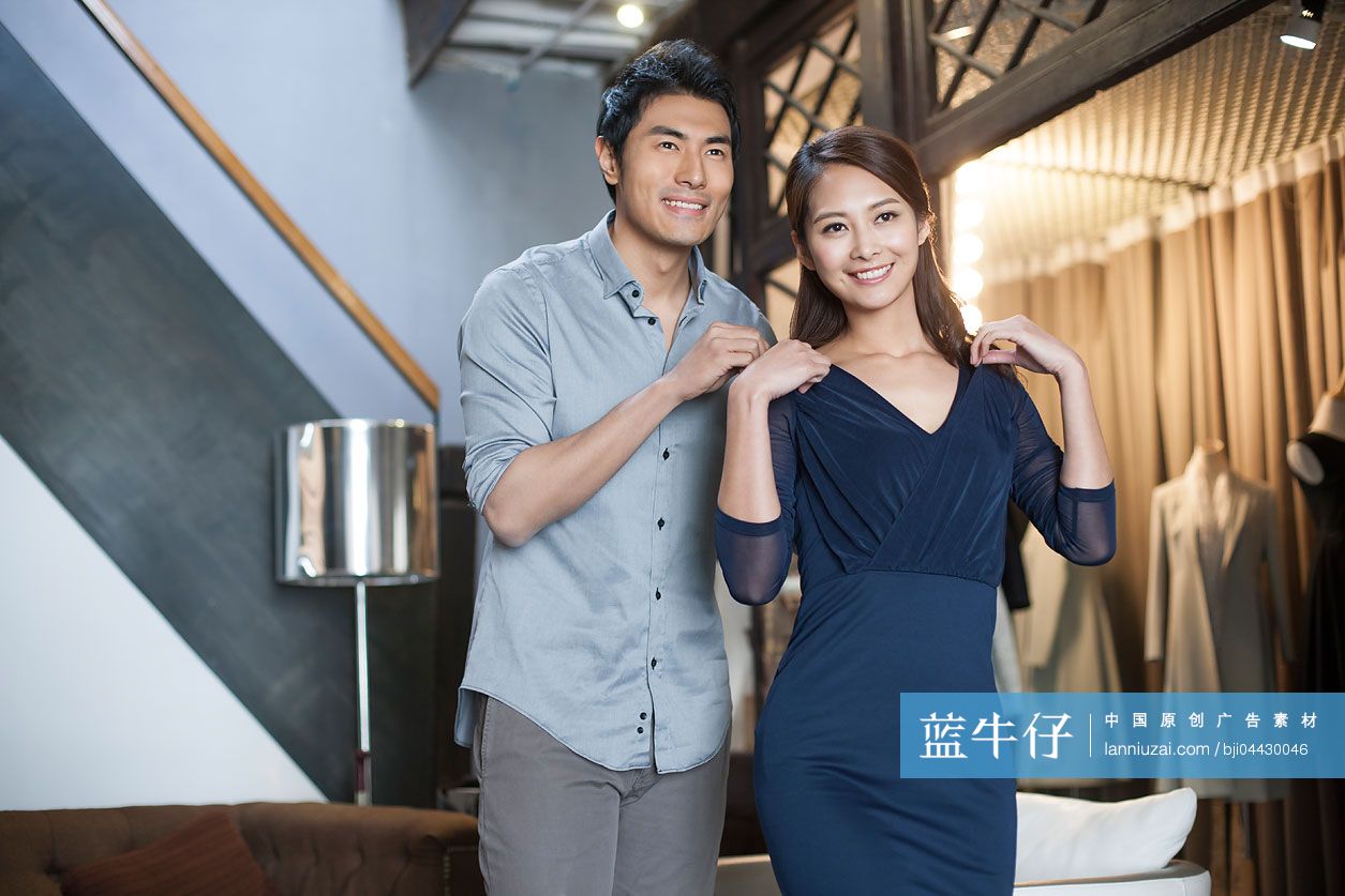 年轻夫妇在服装店挑选衣服
