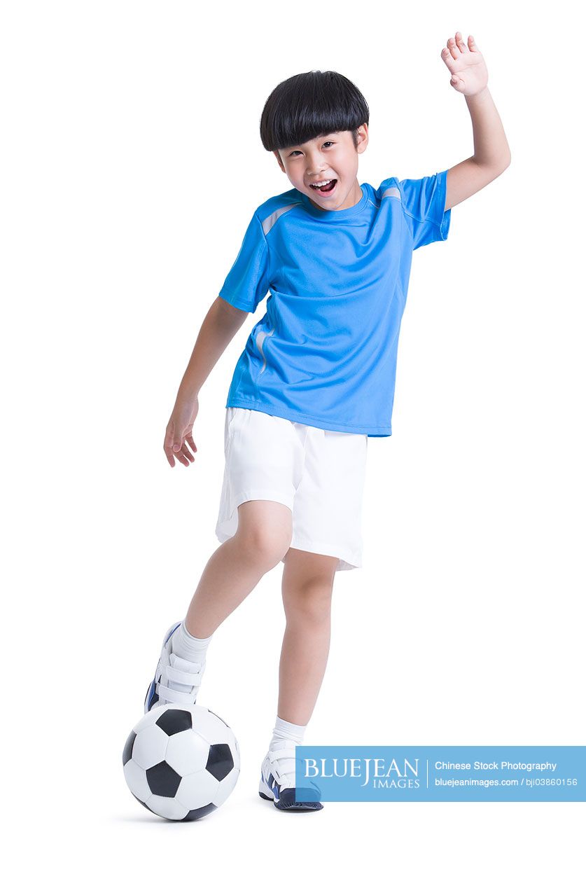 Cheerful Chinese boy playing football