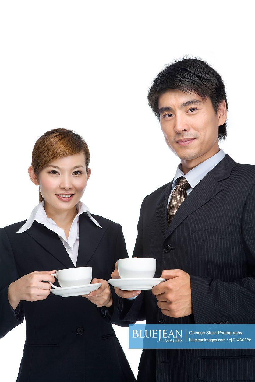 Young Chinese businessman and Chinese businesswoman having coffee together