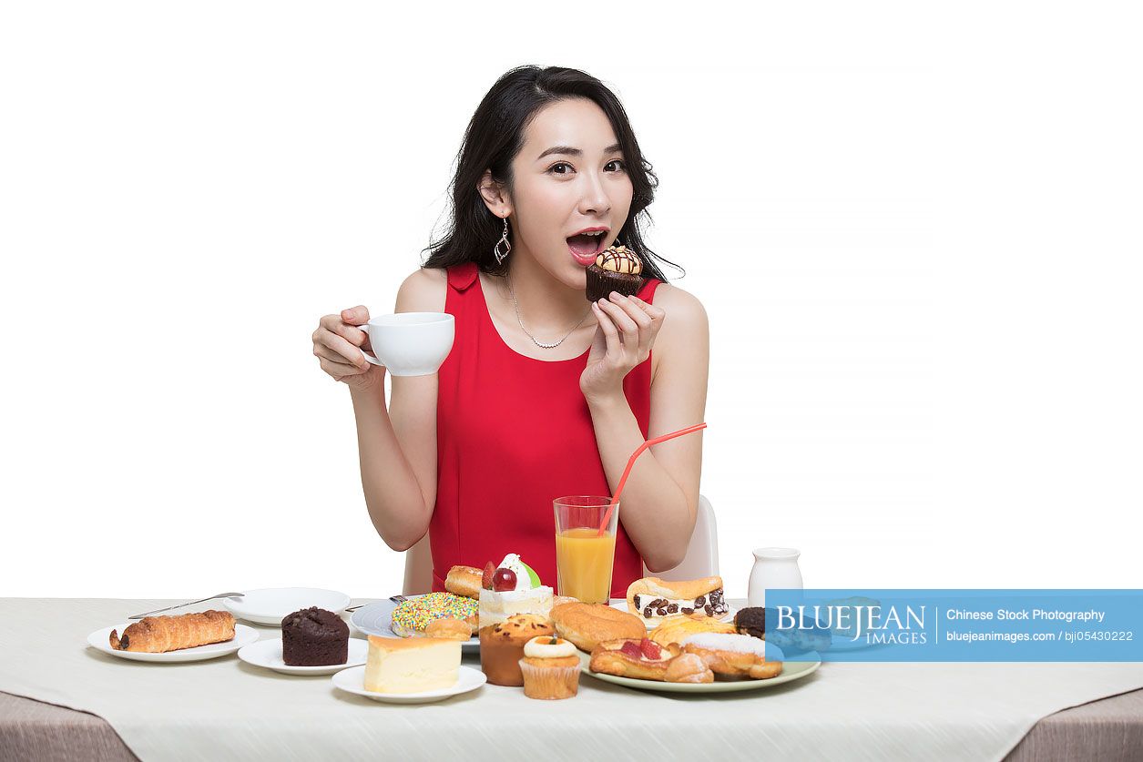 Fashionable young Chinese woman eating dessert