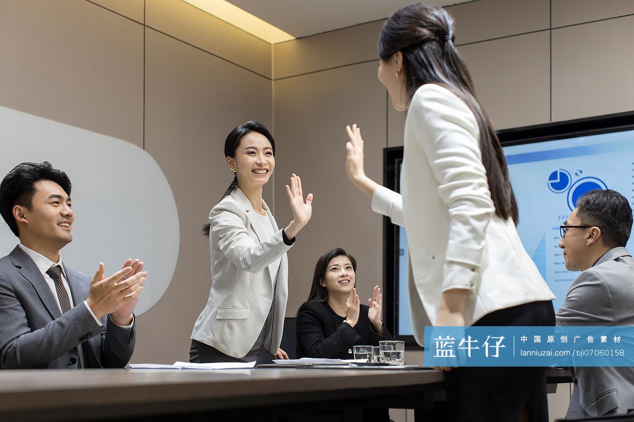 快乐的商务人士在会议室击掌庆祝