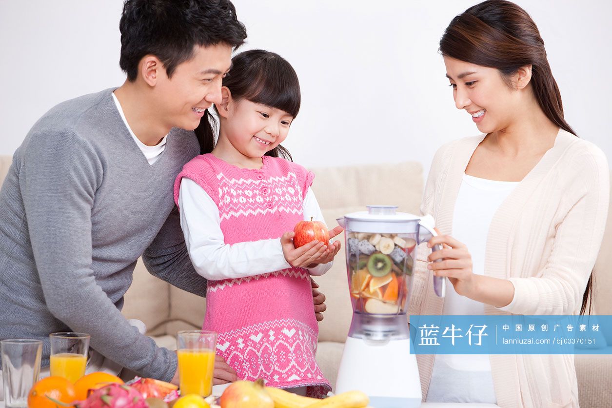 开心的一家人使用榨汁机做果汁