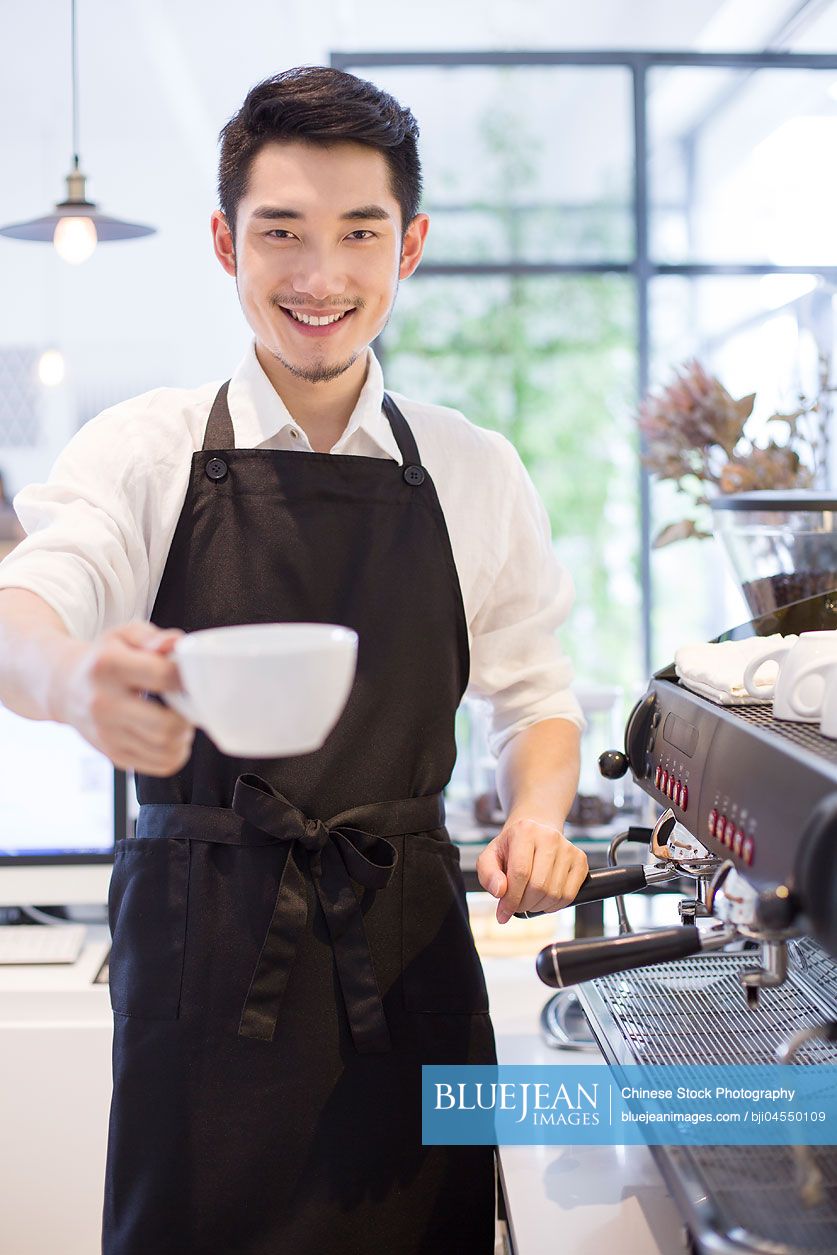 Chinese barista holding a cup of coffee