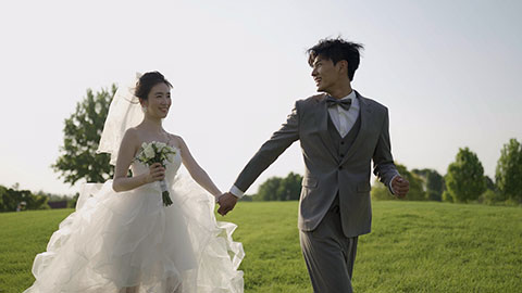Happy bride and groom running on grass