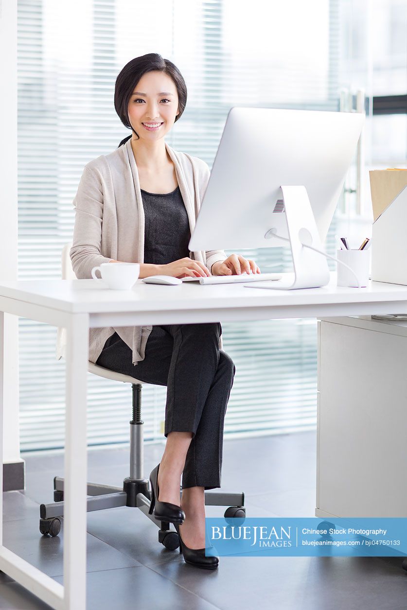 Portrait of young Chinese woman in office