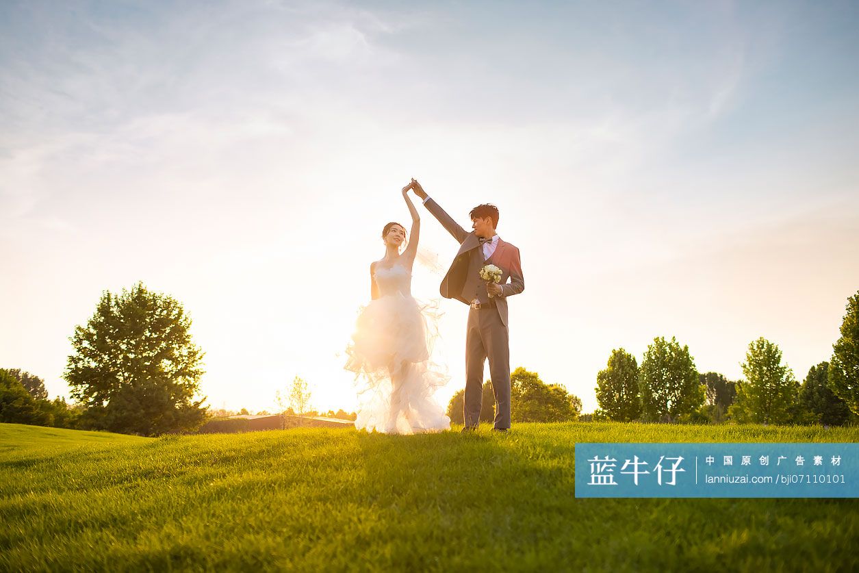 快乐的新郎新娘在草地上跳舞