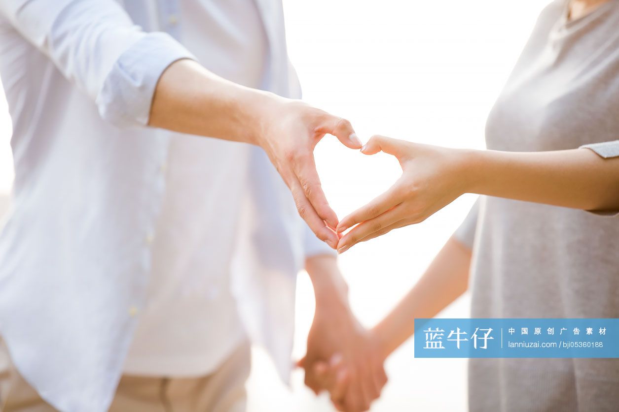 快乐的年轻情侣摆心型手势